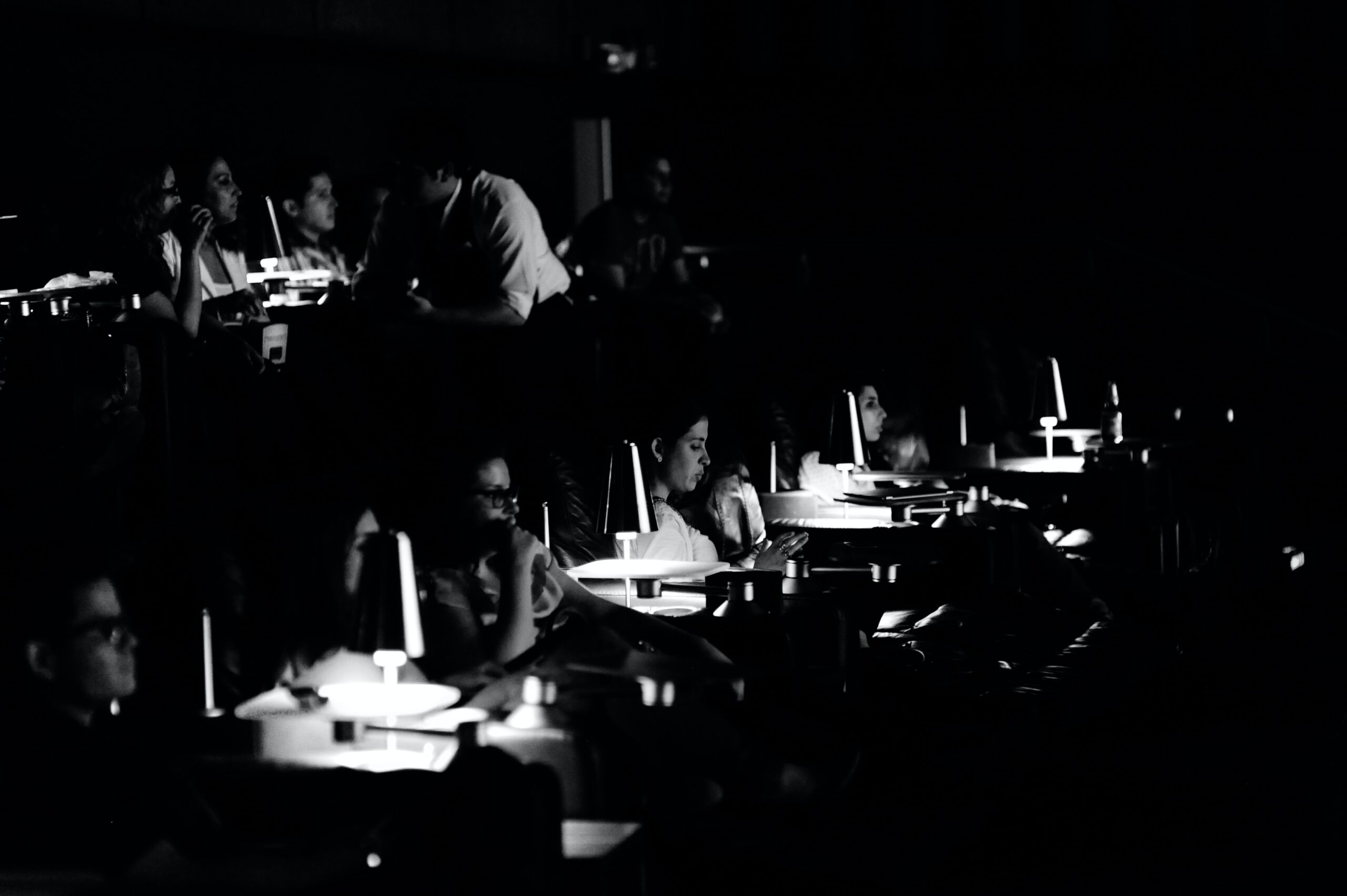 grayscale photo of people sitting on chair